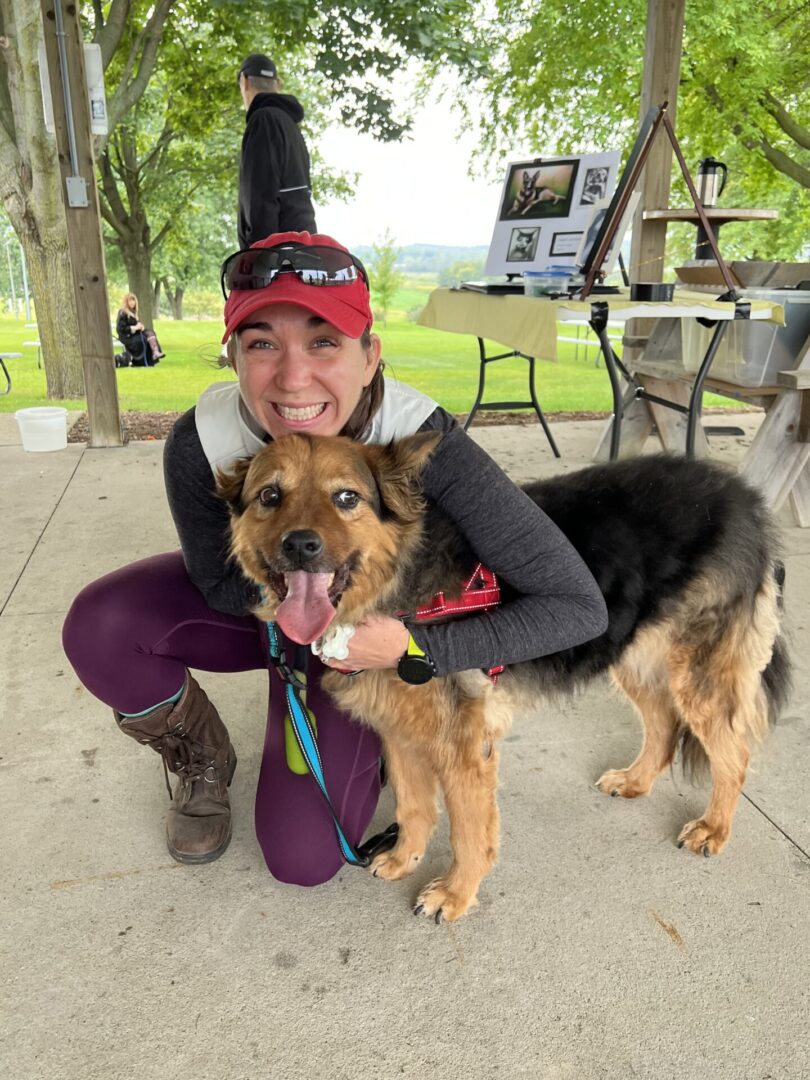 A woman and her dog are posing for the camera.