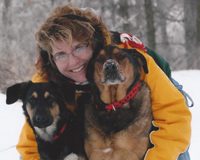 A woman with two dogs in the snow.