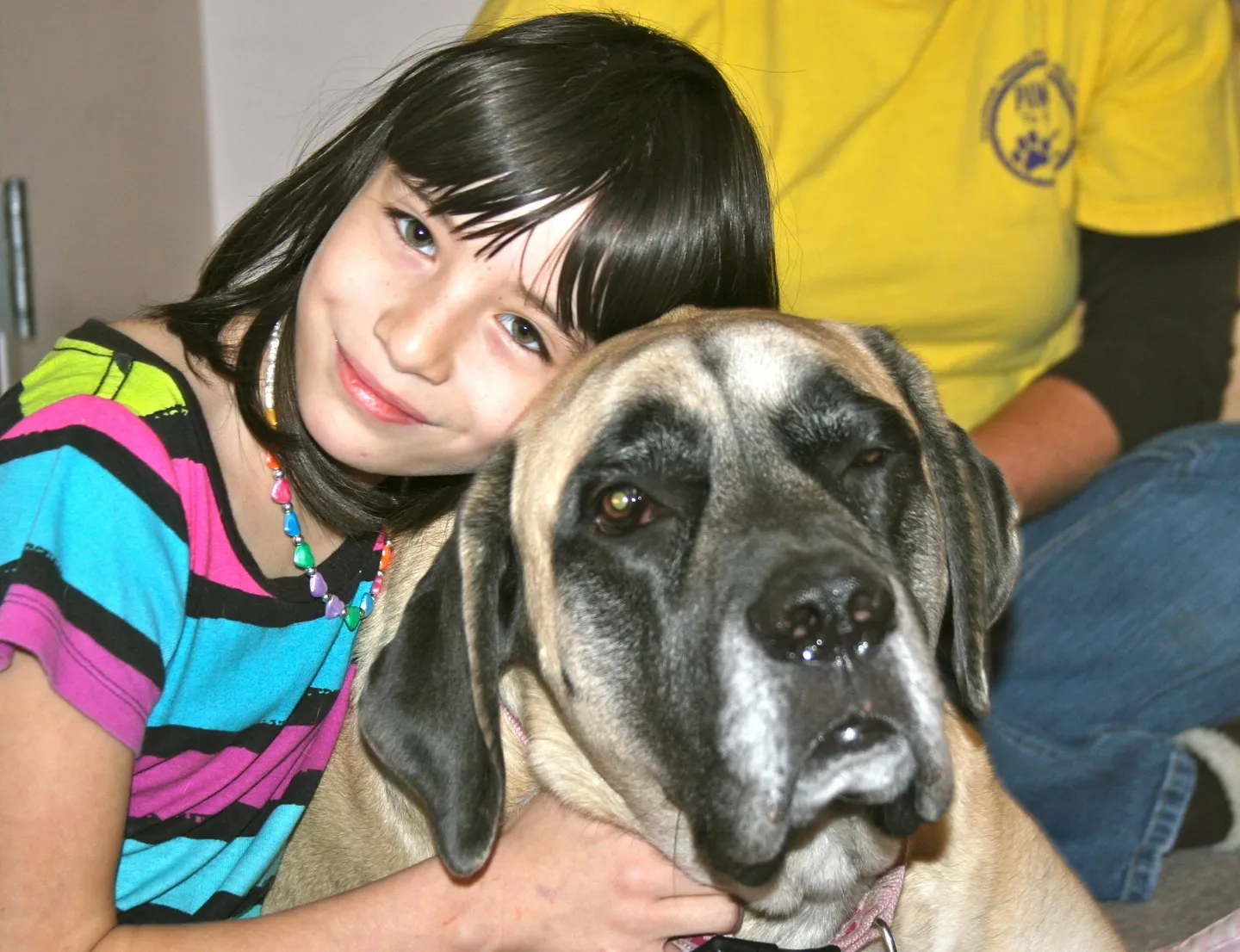 A girl and her dog are posing for the camera.